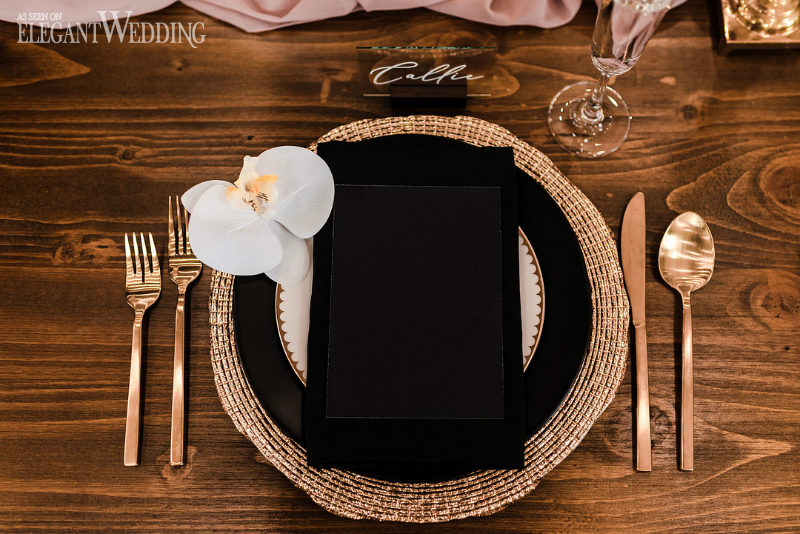 black and gold table setting for a wedding